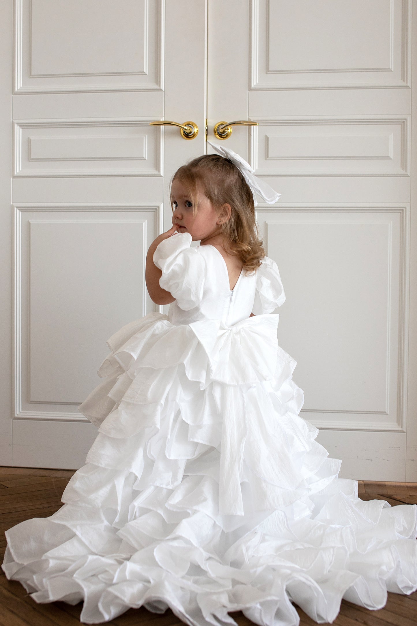 Enfant de 2 ans portant une robe blanche de style princesse avec traîne
