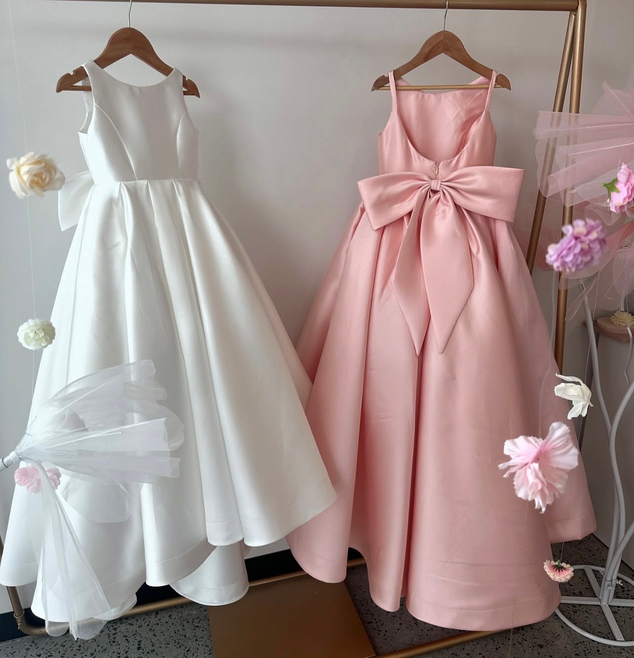 Deux robes fille mariage blanc ivoire et rose blush sur cintre