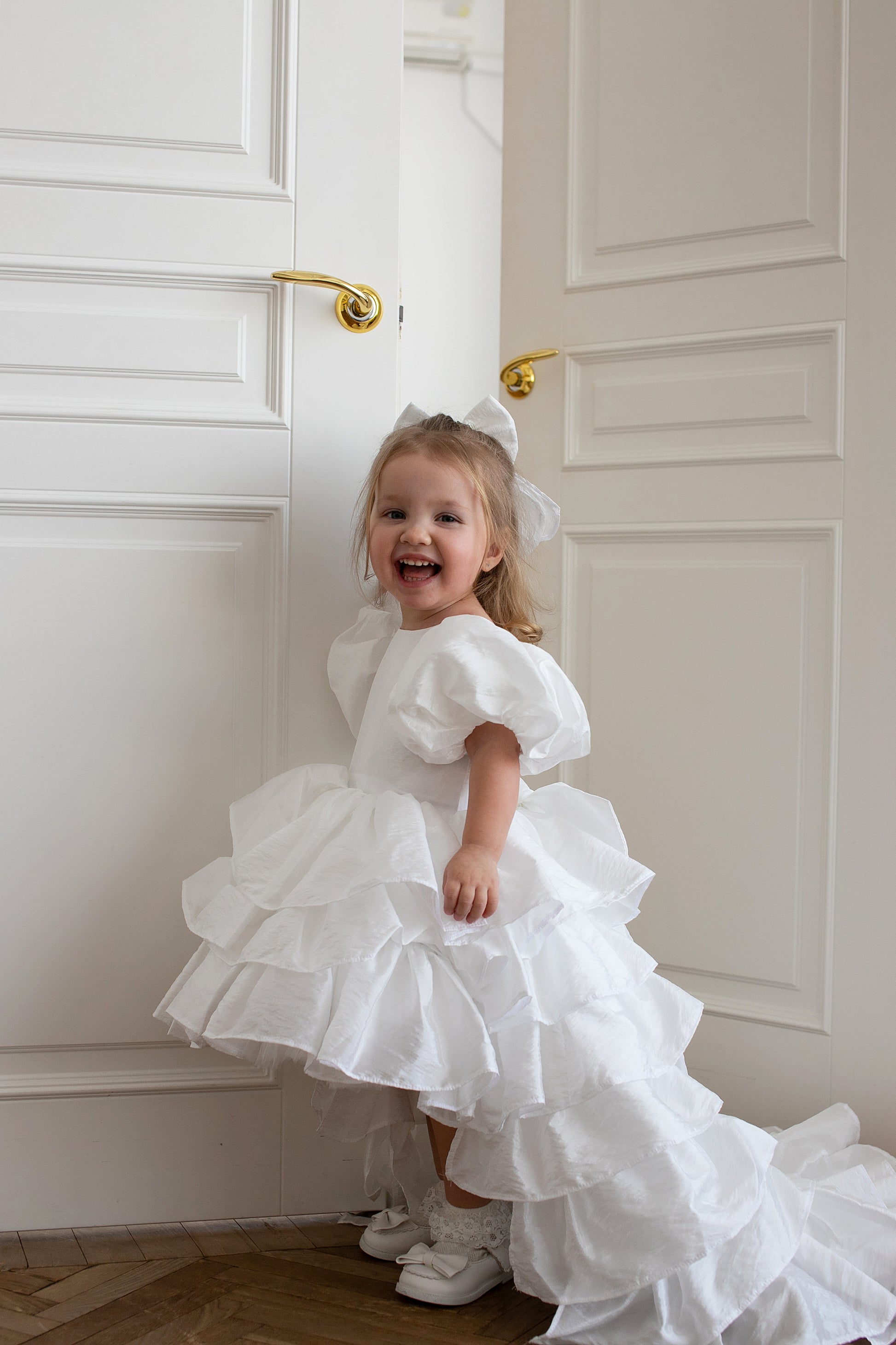 Enfant de 2 ans en robe blanche à étages, style élégant avec traîne