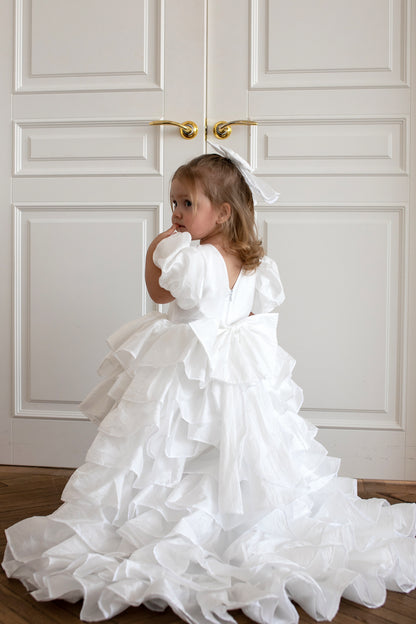 Enfant de 2 ans portant une robe blanche de style princesse avec traîne
