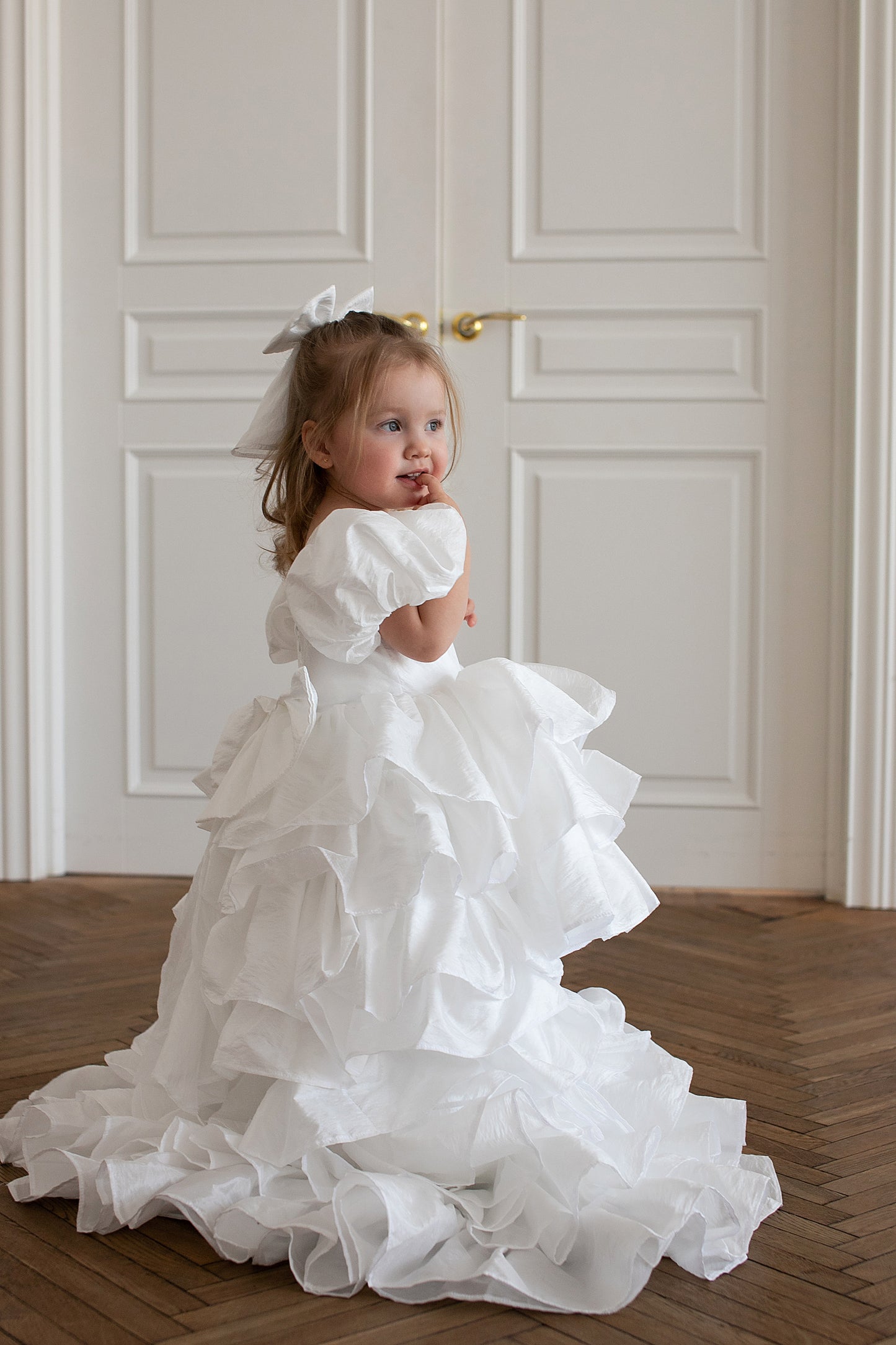 Robe blanche à étages avec traîne portée par une fille de 2 ans